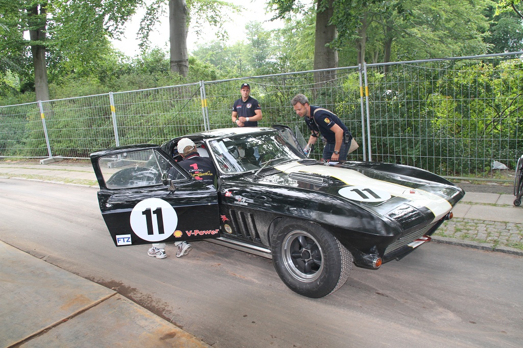 Henrik Johannesen tjekker lige med racerkøreren Fritz Trøst Hansen om hans historiske Chevrolet Covette er OK, imens en ny gæst bliver sat i bilen.
(Foto: Motorsporten.dk)